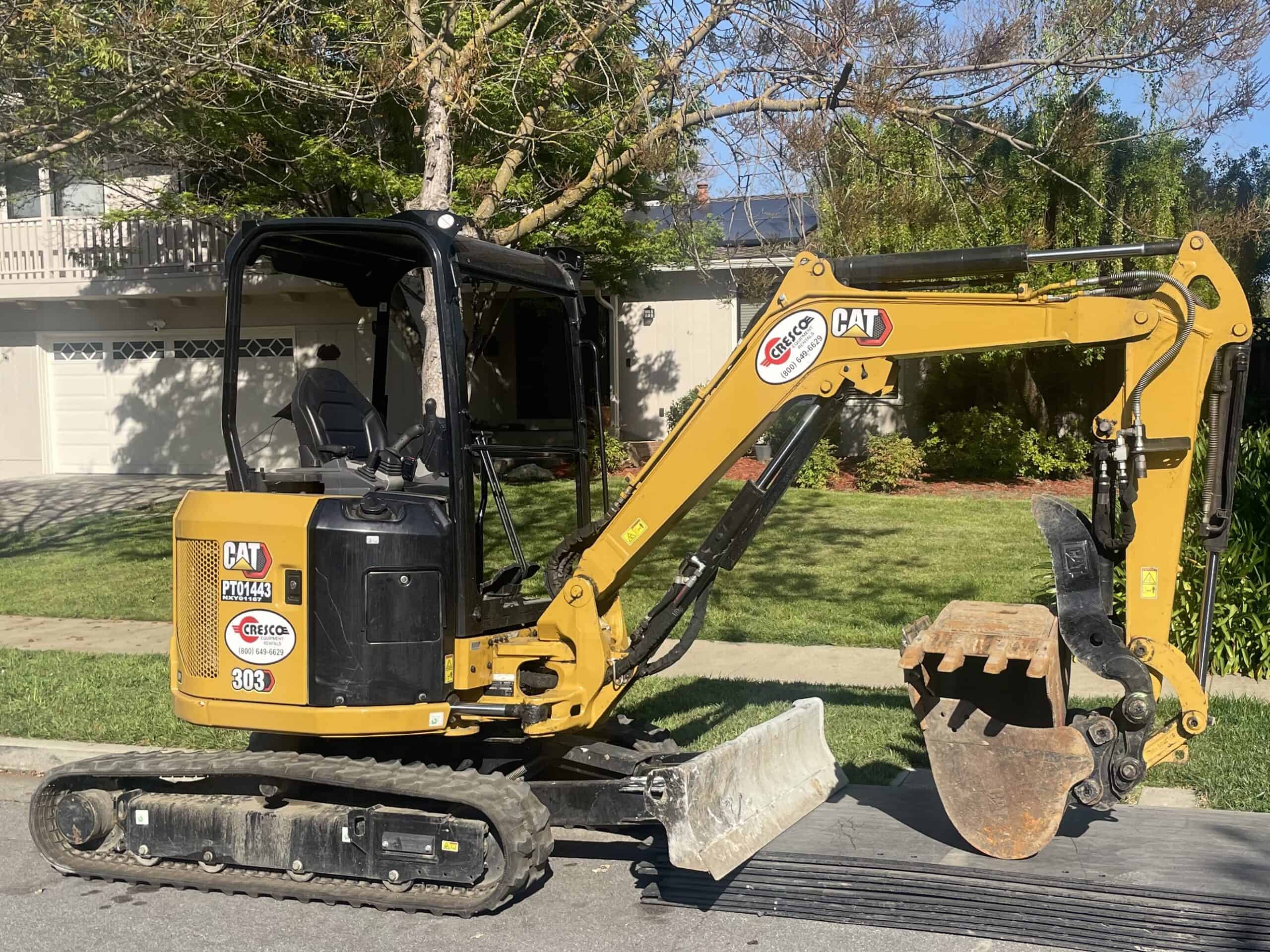 CAT Mini Excavator parked in front of a home